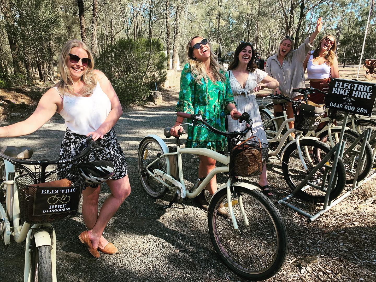 Couple and friends riding e-bikes through the vineyards of the Hunter Valley